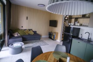 Wyjazd ze znajomymi w góry: część dzienna domu w Campo Resort z narożnikiem do spania, stołem jadalnym i aneksem kuchennym