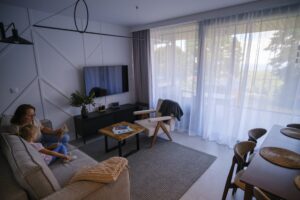 Rodzina w części dziennej domu Campo Resort w Zieleńcu - wspólna przestrzeń salonu z jadalnią
