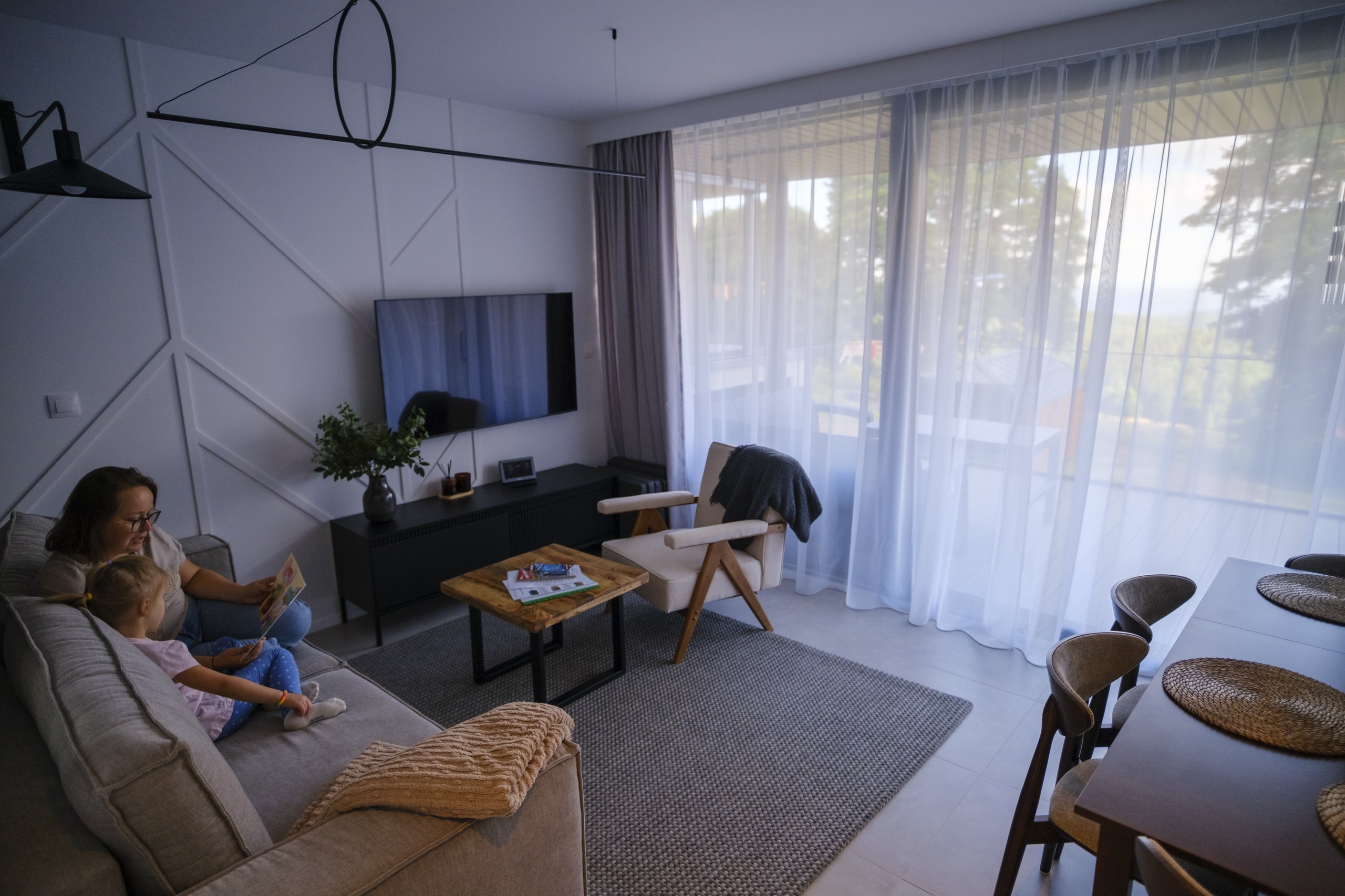 Rodzina w części dziennej domu Campo Resort w Zieleńcu - wspólna przestrzeń salonu z jadalnią