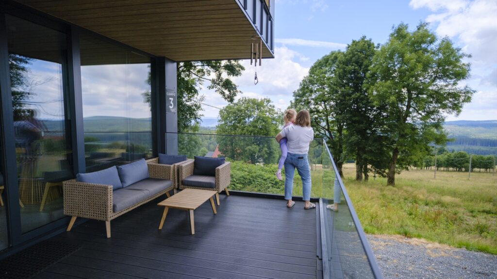 Taras domu w Campo Resort w Zieleńcu z widokiem na łąkę i grzbiety Gór Orlickich